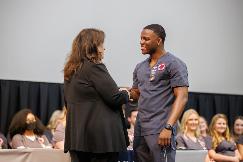 Jonathan Woods shakes hands with dean during Pinning Ceremony.